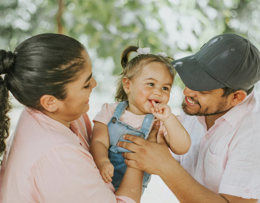 happy parents smiling and holding happy baby