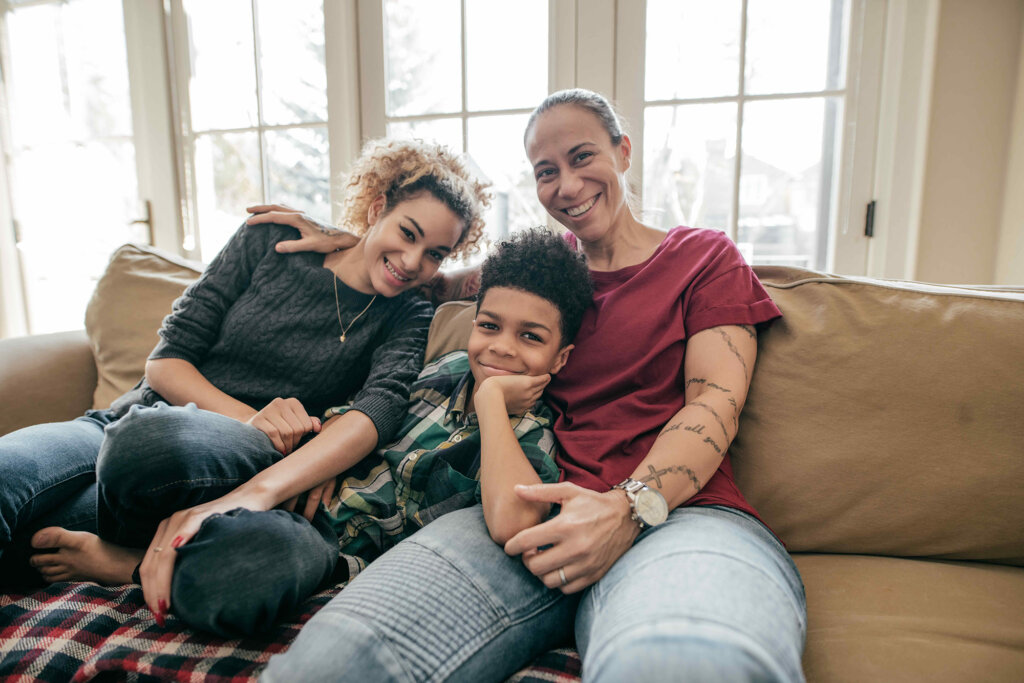 Two women and a boy sitting and smiling.