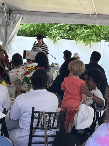 crowd listening to woman speak at podium