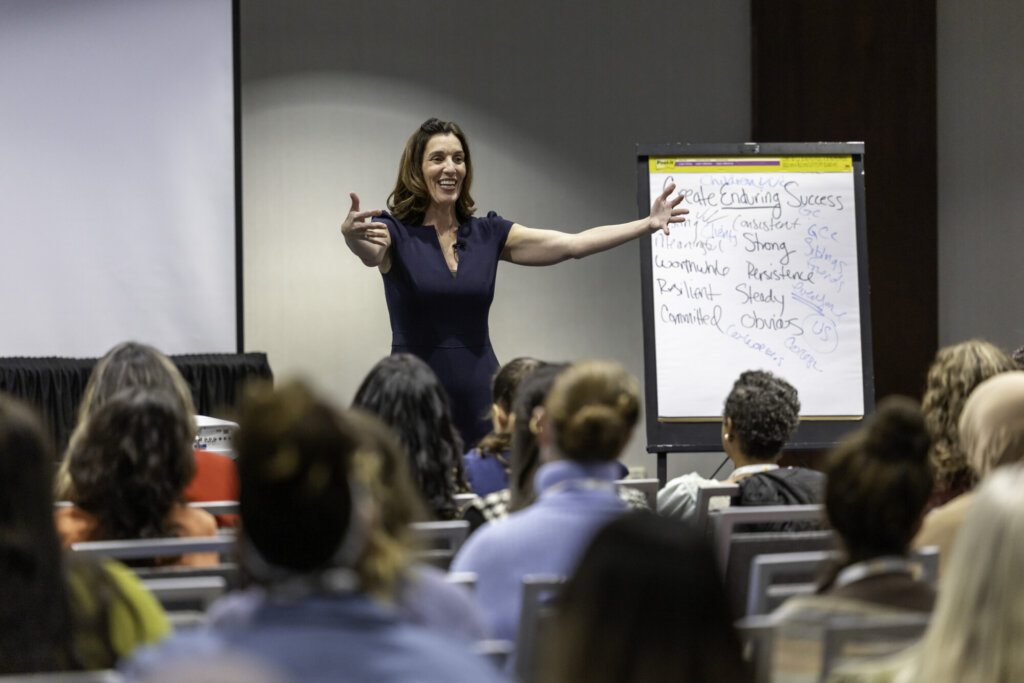 A presenter speaking in their session to a room of attendees.