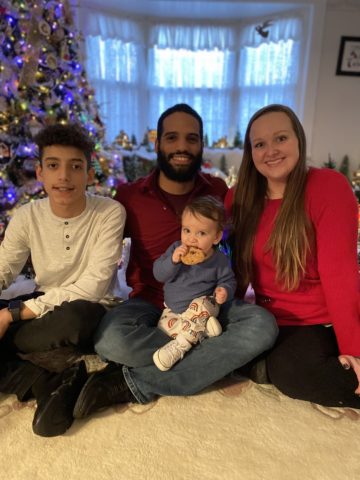 family sitting in front of Christmas tree