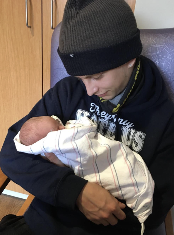 Andrew holding his newborn baby at the hospital