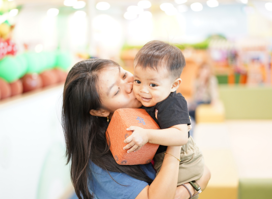 Mother holding and kissing her child